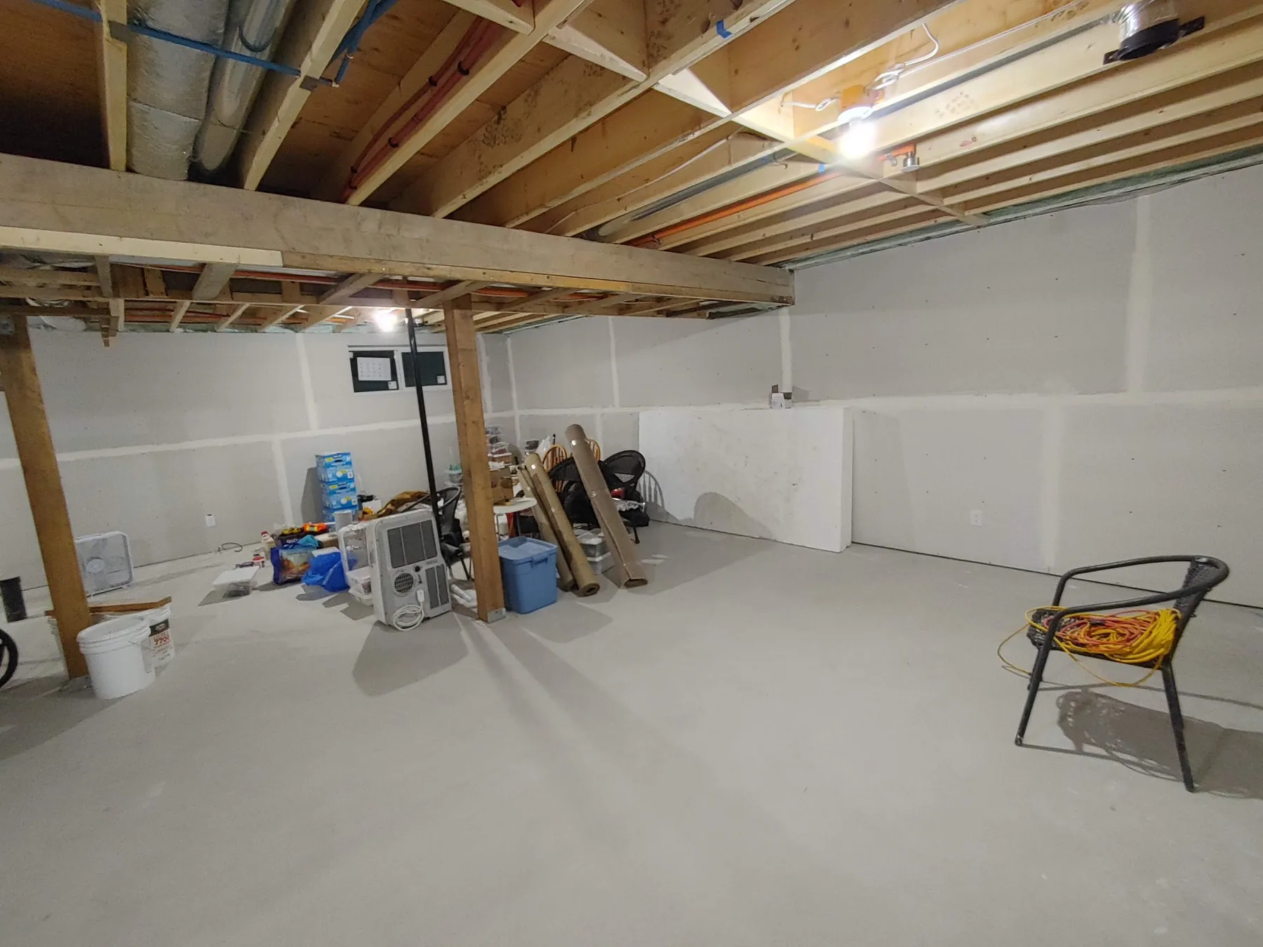 Electrical rough-in running through exposed floor joists during a basement renovation