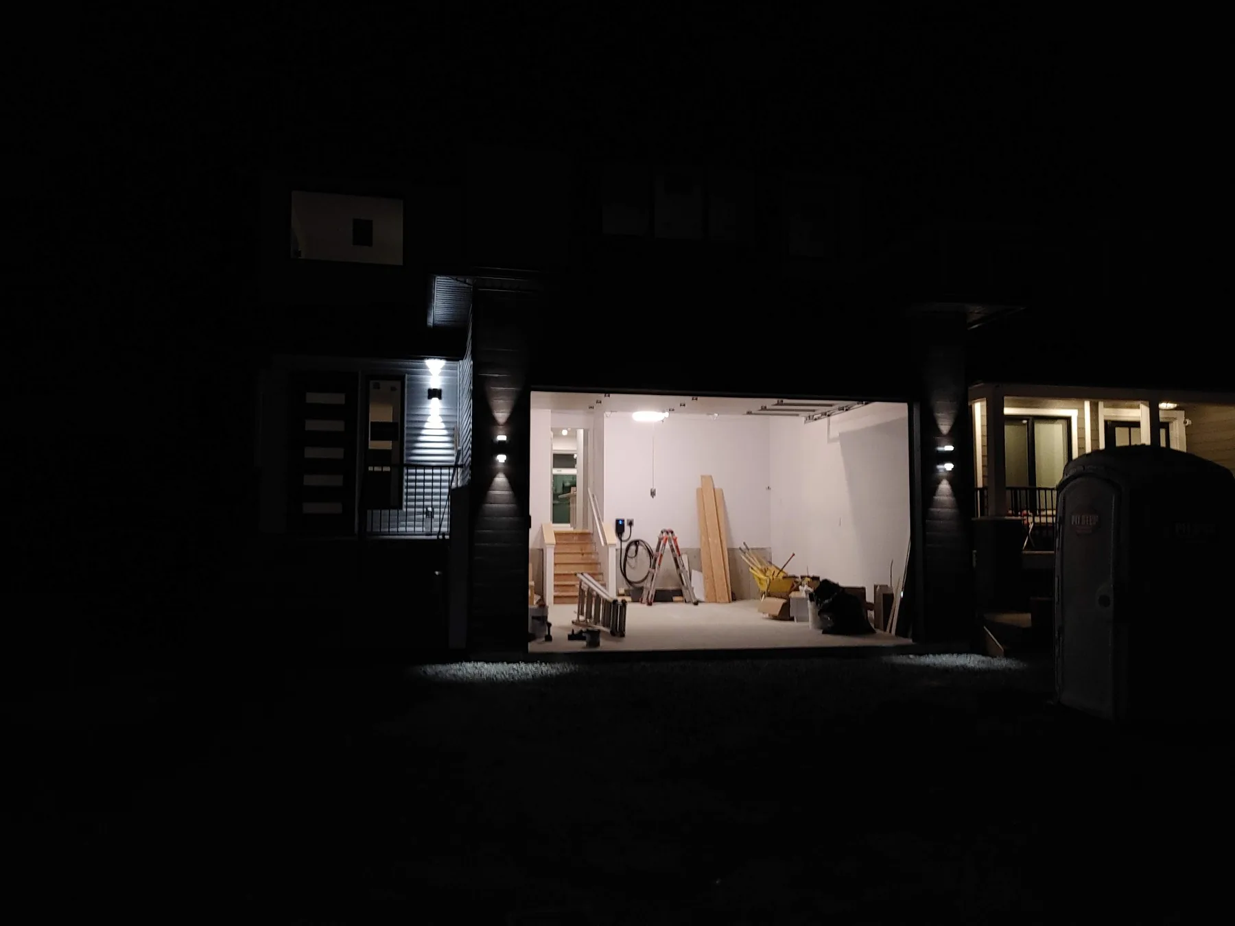 Exterior and garage lighting illuminating a home at night