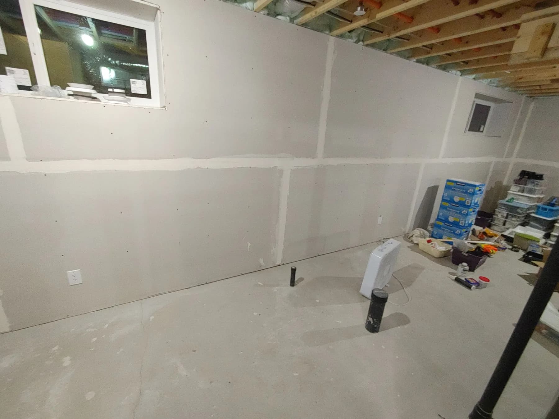 Circuit rough-in along a prepared foundation wall before drywall