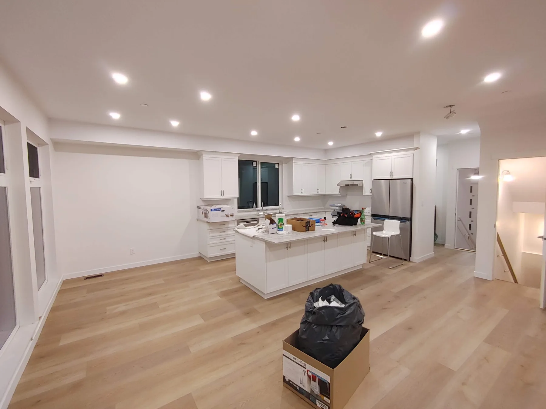 Recessed lighting installed across an open-plan kitchen and living area