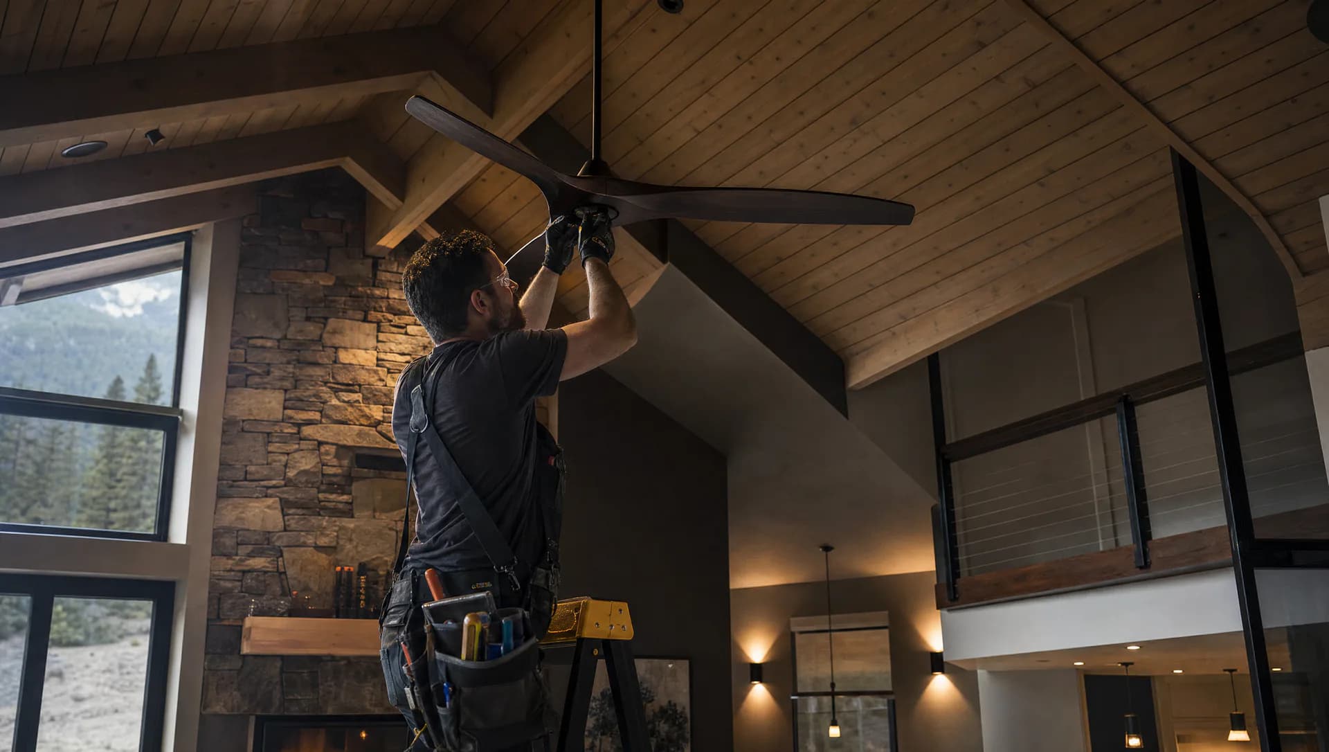 Electrician installing a modern ceiling fan in an upscale British Columbia home