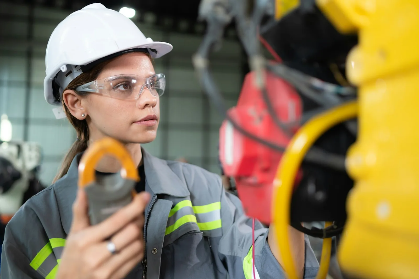 Electric vehicle charging installation - a female engineer inspects the electrical system of every robotics arm