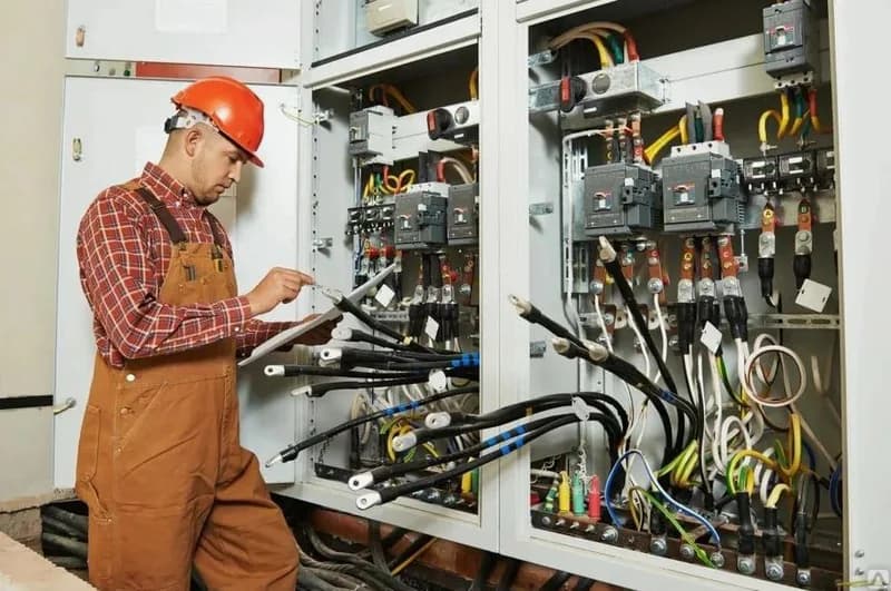Electrician inspecting commercial electrical distribution equipment
