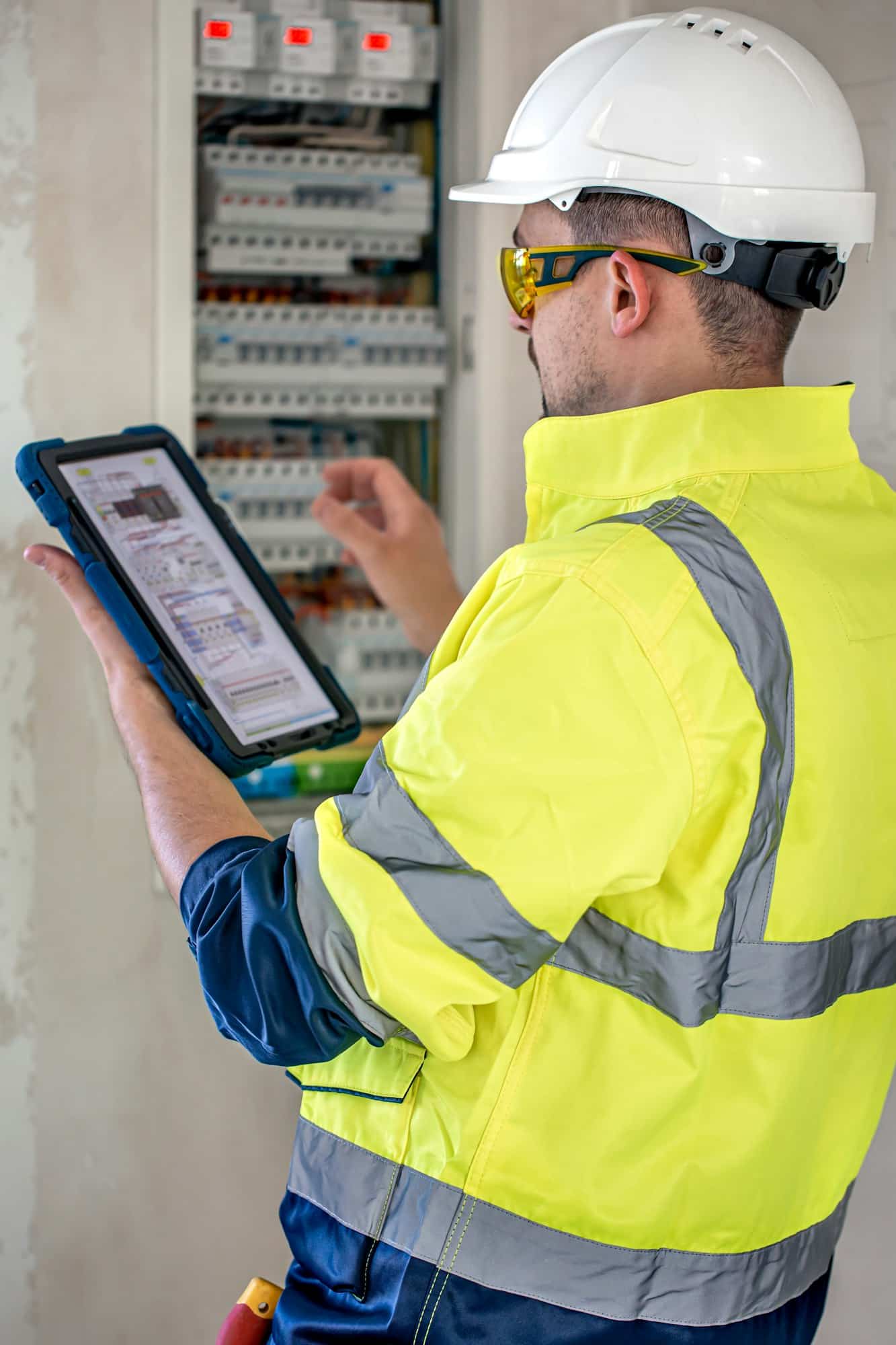 electrical technician looking focused while working in a switchboard with fuses