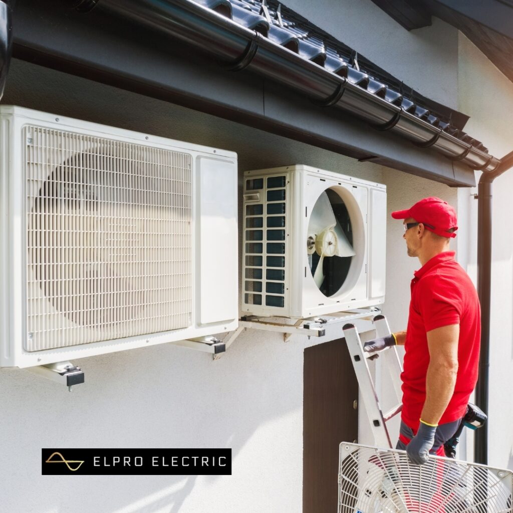 a man on a ladder on a ladder with a fan on a white wall vancouver electrician heat pump solutions